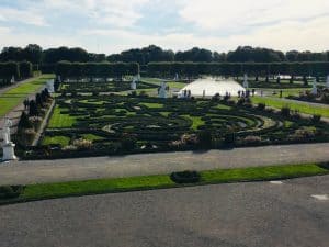 A view over part of the Grosser Garten in the Royal Gardens of Herrenhausen.  You can see a swirling geometric patterns cut into the lawn and a small fountain 