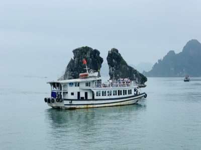 A cruise boat in front of the "two chickens kissing" set of rocks in Ha Long Bay