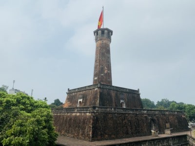 The Flag Tower in Hanoi.  This has a wide stone base and flag hanging from the top of the tower.