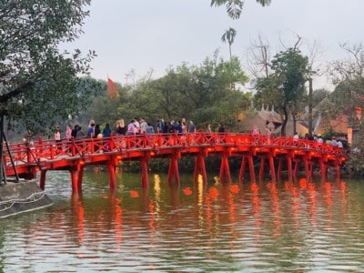 The pretty red bridge that you walk across to reach the Ngoc Son Temple.  There are people walking across to this and it is lit up.