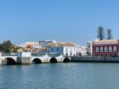 Tavira's Roman bridge with the river in the front and colourful buildings behind