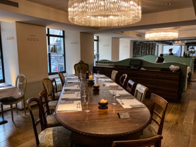 Here you can see a long wooden table where a group could be seated to have their brunch in Zurich.  There is a large chandelier hanging above the table