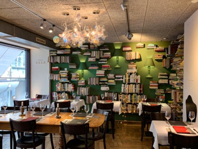 The back of the restaurant.  It is decorated with books and low level lighting on a green background. 