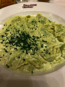 A picture of the ravioles dish in Brasserie Georges.  The pasta is a light green with herbs on the top.