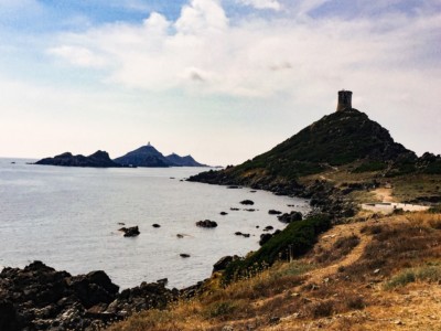 A view of the tower on the cliff and the Sanguinaires archipelago in the sea in the background.  The land is in silhouette.