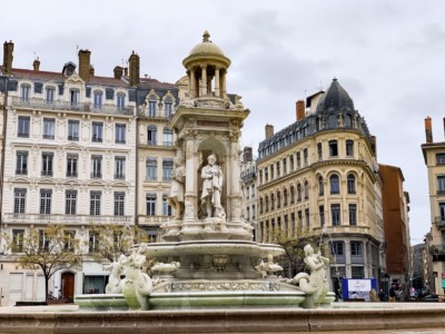 The Place des Jacobins. This image shows grand buildings in the background with a fountain in the foreground.