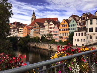 Day trips from Stuttgart: A view of Tubingen from the bridge over the river. The timbered coloured houses line the river and the cathedral is behind in the background
